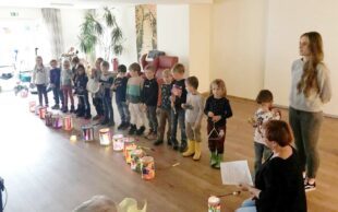 Kindergartenkinder tragen Licht in das Nachbarschaftshaus
